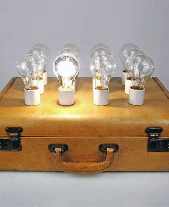 Image of a briefcase with 8 lightbulbs but only one is lit